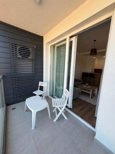 a balcony with a white chair and a table at City Break Sarajevo in Sarajevo