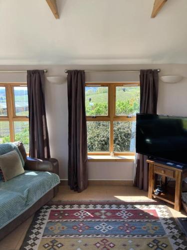 a living room with a couch and a flat screen tv at The Bothy in Lumphanan