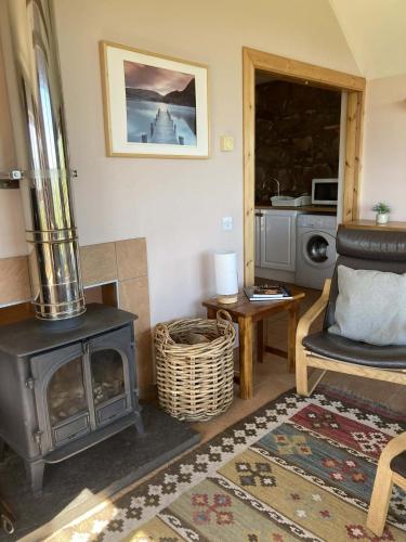 a living room with a fireplace and a stove at The Bothy in Lumphanan