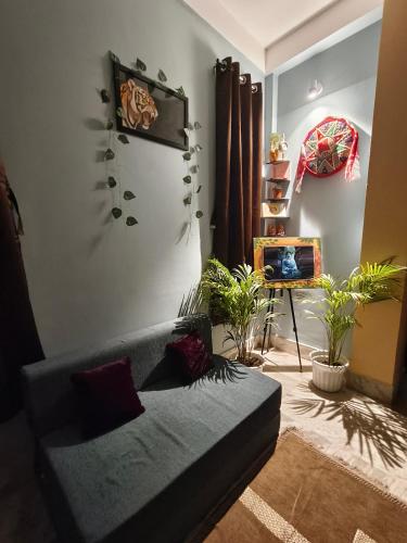 a living room with a couch and potted plants at Jonaki Aalay-Cozy and Budget Stay-Ulubari in Guwahati