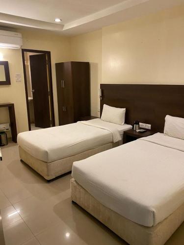 a hotel room with two beds in a room at Hotel Blu Ivy in Chennai