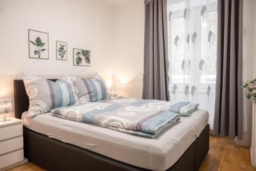 a bedroom with a bed with blue and white pillows at Paky Appartements 00322 in Bruck an der Leitha