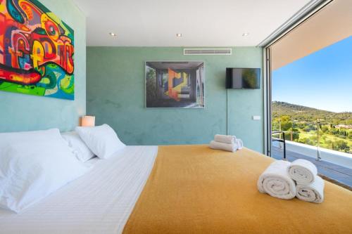 a bedroom with a large bed with towels on it at Villa Roca Llisa in Santa Eularia des Riu
