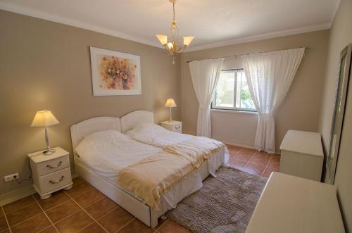 a bedroom with a white bed and a window at Bonita by Algarve Holidays in Quarteira