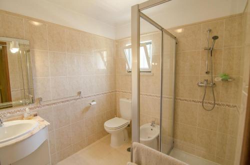 a bathroom with a shower and a toilet and a sink at Bonita by Algarve Holidays in Quarteira