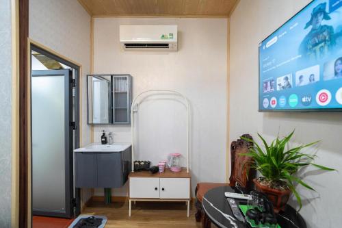 a bathroom with a sink and a tv on the wall at Home Đăng Hải in Phú Hiệp
