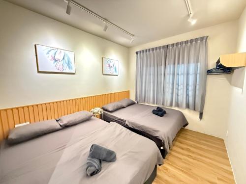 two beds in a room with a window at Mujito5 15Pax 3BR NearTC, DinosaurLand, PS4 Netflix in Kuantan