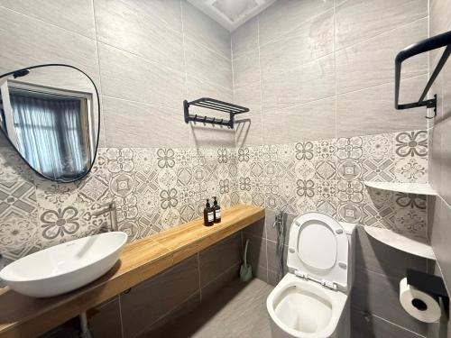 a bathroom with a sink and a toilet and a mirror at Mujito5 15Pax 3BR NearTC, DinosaurLand, PS4 Netflix in Kuantan