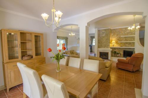 a dining room and living room with a wooden table and chairs at Bonita by Algarve Holidays in Quarteira