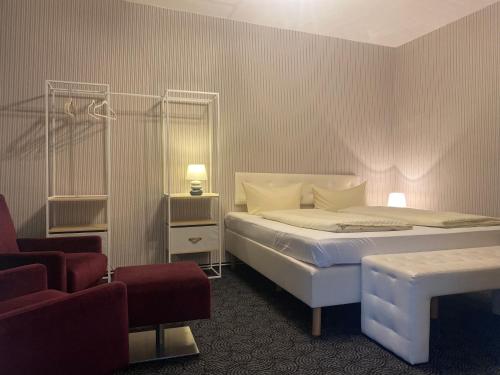 a hotel room with a bed and a chair at Deutsches Haus in Malchow