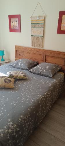 a bed with a wooden headboard and two pillows at appartement Anna in Parentis-en-Born