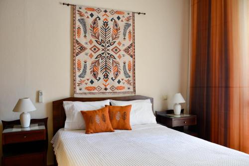 a bedroom with a bed with orange pillows and a painting on the wall at Filomeni's house in Kavála