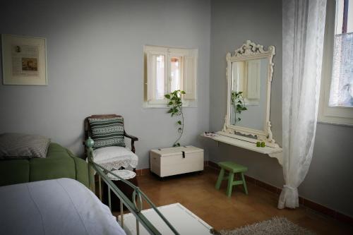 a bedroom with a green couch and a mirror at La Pausetta in Foligno