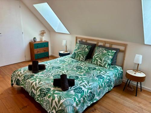 a bedroom with a bed with a green comforter at Le domaine du Quercy in Padirac