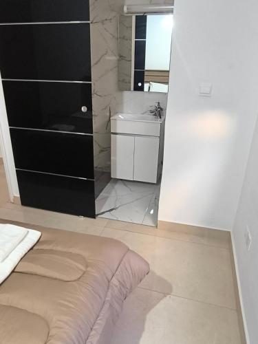a bedroom with a bed and a sink and a mirror at Eva Luxury Apartment in Paphos