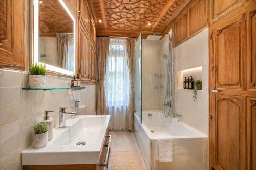 a bathroom with a sink and a shower and a tub at Firdous Houseboats at Dal Lake in Srinagar
