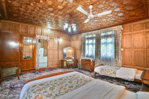 a bedroom with a large bed and wooden walls at Firdous Houseboats at Dal Lake in Srinagar