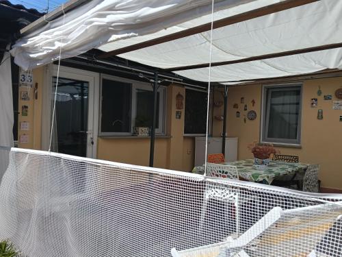 a white canopy over a patio with a table at Casa in giardino in Piombino