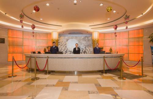 three men standing at a podium in a lobby at Shu Guang International Hotel in Nanjing