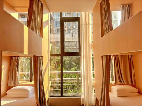 a bedroom with a large window with curtains at F18 Hub Youth Hostel in Chengdu