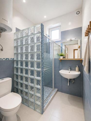 a bathroom with a shower and a toilet and a sink at DOMKI NA FALI by Baltic Club in Sarbinowo