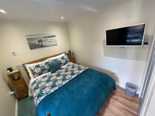 a bedroom with a bed and a flat screen tv at The Apartment in Nairn