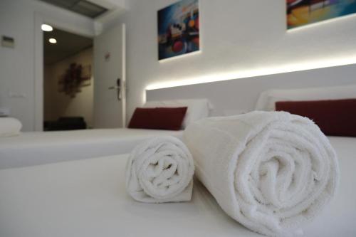 two rolled towels on top of a bed at Hotel Gabriel y Galán in Salamanca