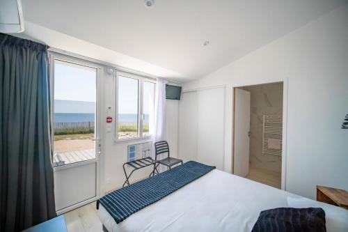 a bedroom with a bed and a view of the ocean at La Villa Saint Jean in Les Sables-d'Olonne