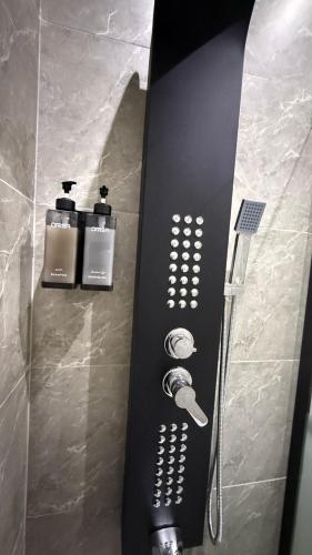 a black surfboard with three bottles ofodorizers in a bathroom at شقق سدايم in Jeddah