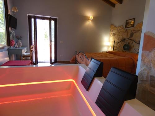 a bedroom with a tub and a bed and a bedroom with a bed istg at Scappo in Umbria, Casale Rusinè in Narni