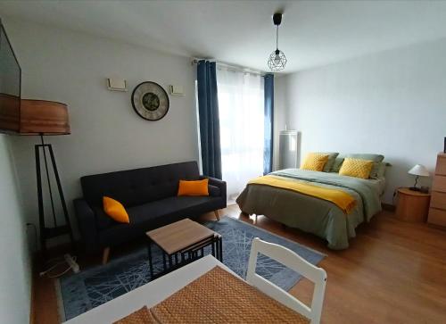 a living room with a bed and a couch at Studio avec parking gratuit in Cenon
