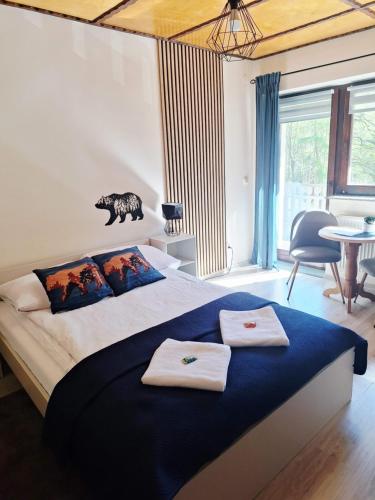 a bedroom with a large bed with two towels on it at Pokoje Gościnne Perła in Brenna