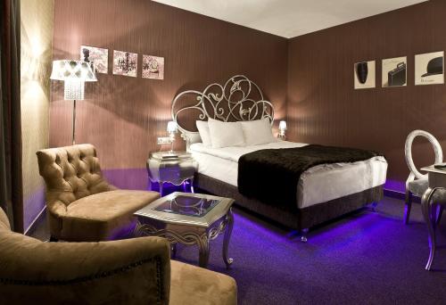 une chambre d'hôtel avec un lit et une chaise dans l'établissement Hotel 3 Trio, à Białystok
