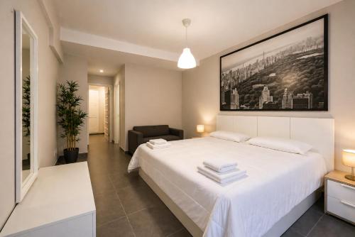 a bedroom with a large white bed and a chair at Nova Suites Viveiro in Viveiro