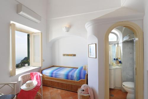 a bedroom with a bed and a bathroom with a window at Casa Alessia in Praiano