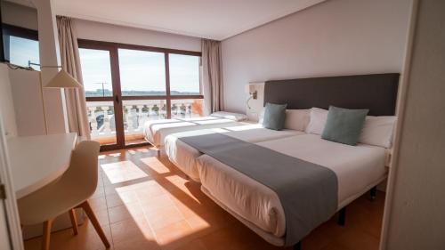 a hotel room with two beds and a balcony at Hotel Bahia Sur in San Fernando