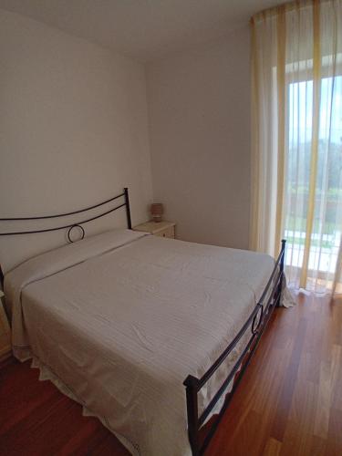 a bed in a bedroom with a large window at Villetta di Laura in Villa San Leonardo