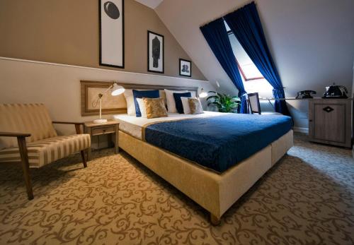 pokój hotelowy z łóżkiem i krzesłem w obiekcie Hotel Jägerhorn w Zagrzebiu