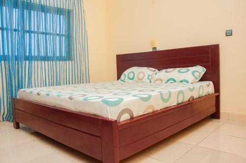 a bedroom with a wooden bed in a room at Résidence Maranatha in Cotonou
