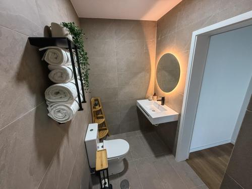 a bathroom with a toilet and a sink and a mirror at Modern Sea View Studio with Private Parking in Gaula