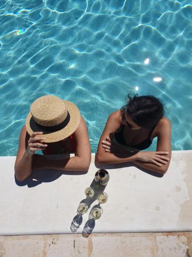 two women sitting in a swimming pool next to the water at Casa Relax Isabelle in Alberobello