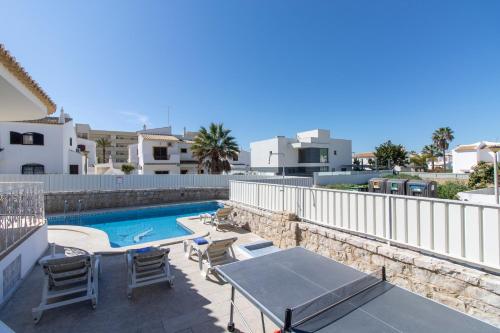 a patio with a table and chairs and a swimming pool at Villa Brisa do Mar by Algarve Holidays in Galé