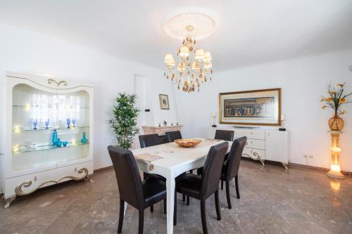 a dining room with a white table and black chairs at Villa Brisa do Mar by Algarve Holidays in Galé