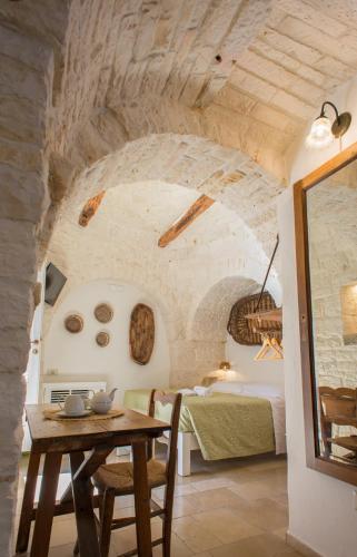 a bedroom with a table and a bed in a room at Trullo Soave Suite - outdoor jacuzzi in Alberobello