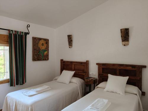 a room with two beds and a window at El Molino de Iramala in Reolid