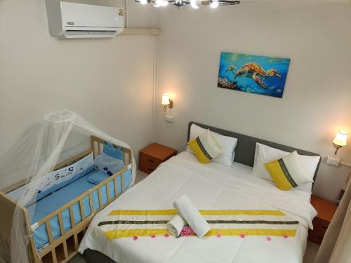 a room with two beds and a baby crib at Mumzai House 2 in Ko Muk