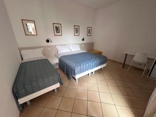 a hotel room with two beds and a table at La Conchiglia in Sperlonga