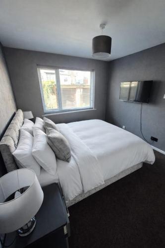 a bedroom with a large white bed with a window at Stylish 2-Bed Flat, Minutes to Southport Centre in Southport
