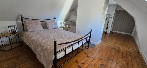 a bedroom with a bed with a wooden floor at La casa valentine in Calais