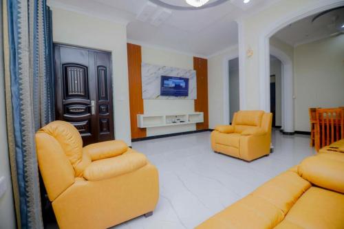 a living room with two yellow chairs and a tv at Zanzibar Residence in Zanzibar City